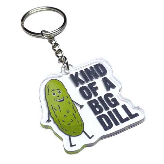 A photo of a vinyl keychain. It has a smiling cartoon pickle on it. Text reads, Kind of a Big Dill.
