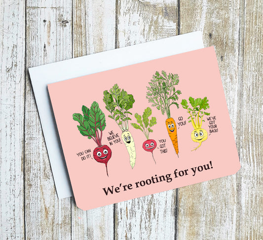 A photo of a greeting card. It has cartoon root vegetables on it sending messages of positivity, 'You can do it, We believe in you, You got this, Go You, We've got your back!' Text below reads, We're rooting for you!