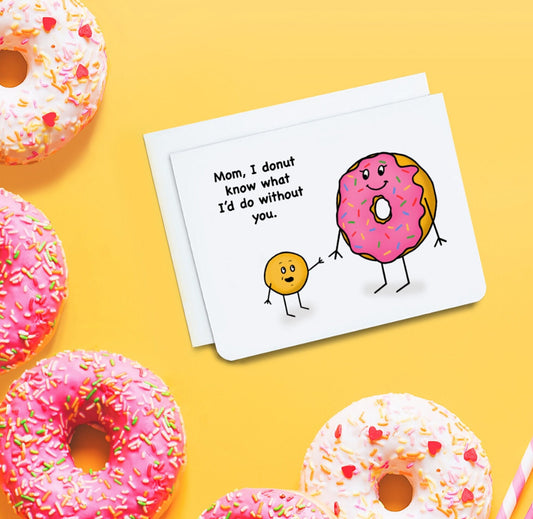 A photo of a Mother's Day card. It has a small ball of dough smiling at a large pink donut. Text reads, Mom, I donut know what I'd do without you.