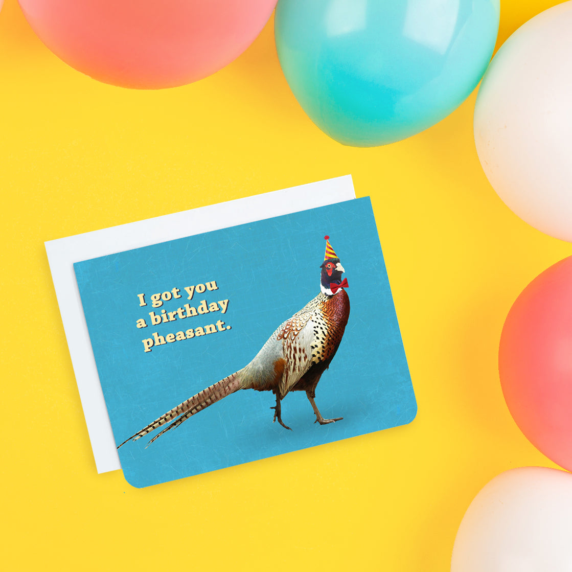 A photo of a blue birthday card. It has a photo of a strutting pheasant on it. It's wearing a bow tie and a party had. Text on card reads, 'I got you a birthday pheasant.'
