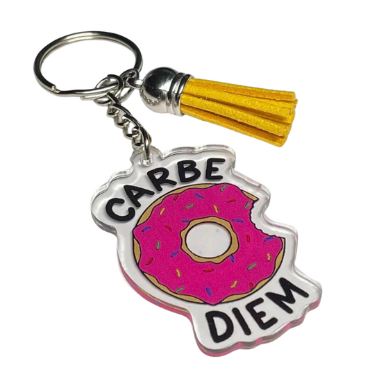 A photo of a funny keychain. It has a pink bitten donut on it. Text reads, Carbe Diem.