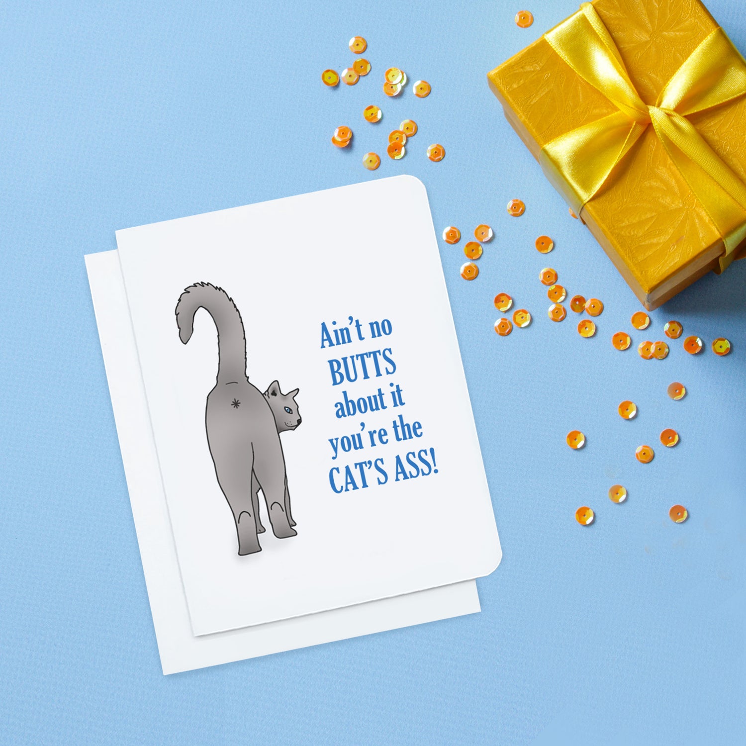 A photo of a white anniversary card. It has a grey cat showing its butt. Text on card reads, 'Ain't no butts about it you're the cat's ass!'