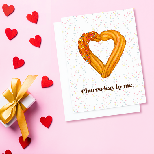 A white valentines card. It has churros in the shape of a heart. Text reads, Churro-kay by me.