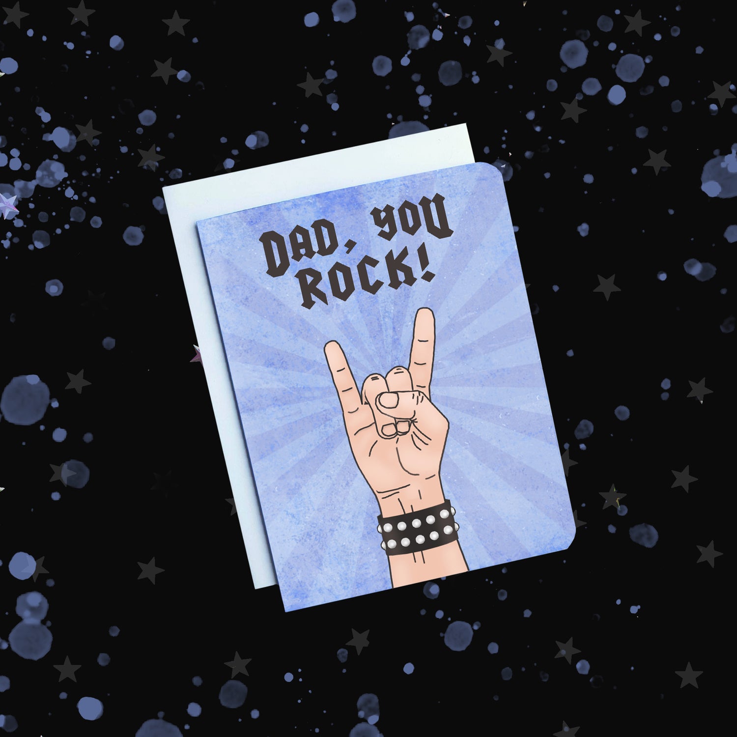 Photo of a fathers day card. It has a hand giving the rock symbol on it. Text reads, Dad, You Rock!