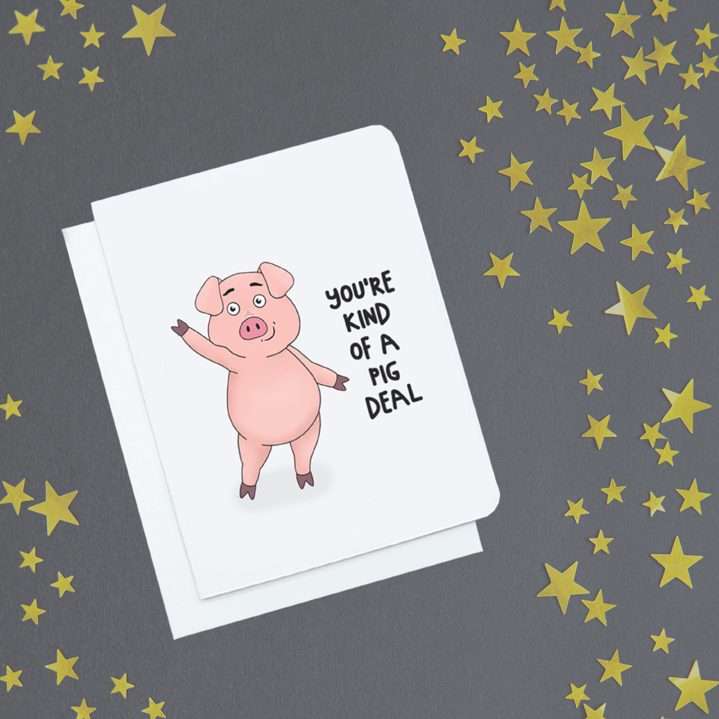 A photo of a white greeting cards. It has a waving cartoon pig on it. Text reads 'You're kind o a Pig deal.'