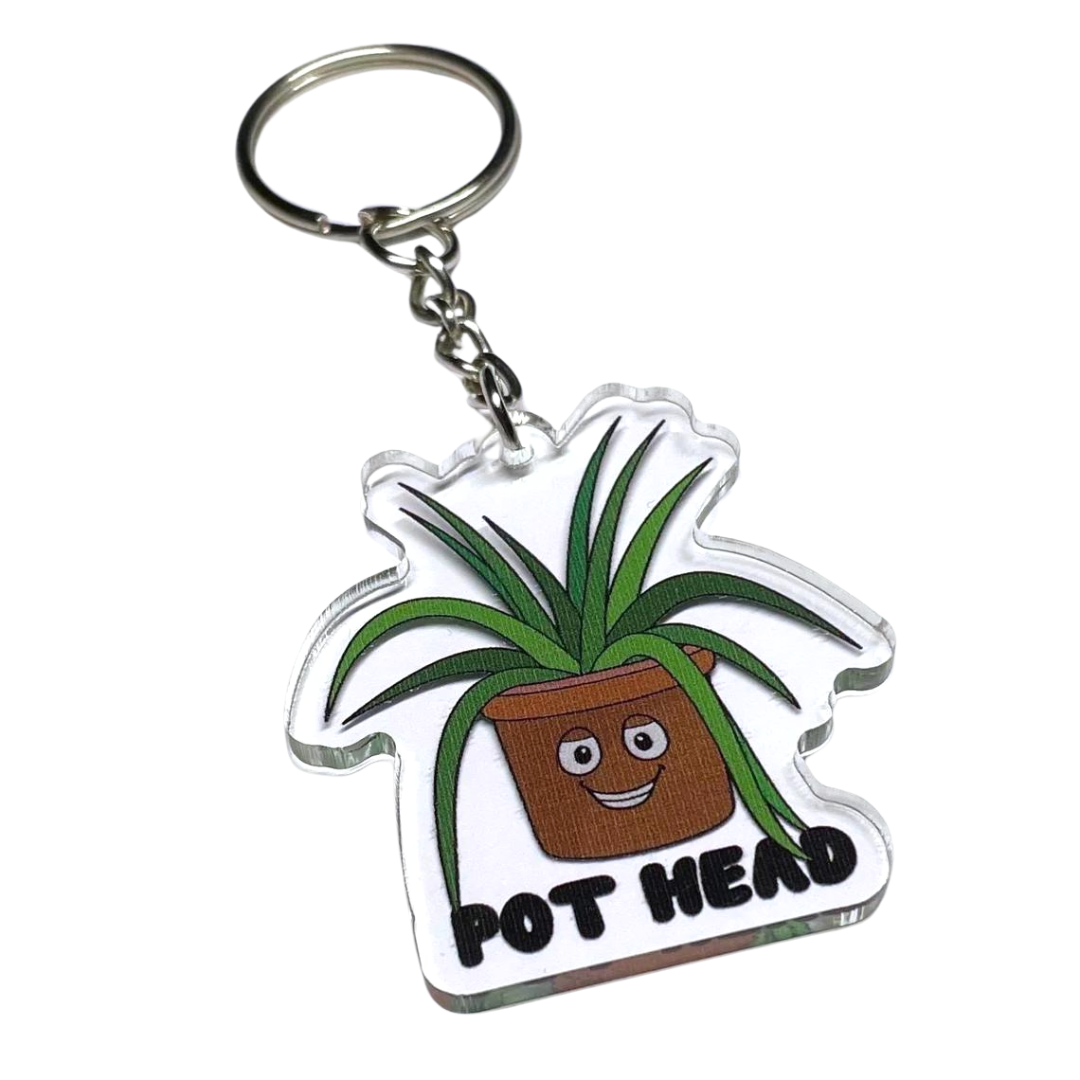 A photo of a fun keychain. It has a smiling cartoon pot plant on it.  Text reads, Pot Head.
