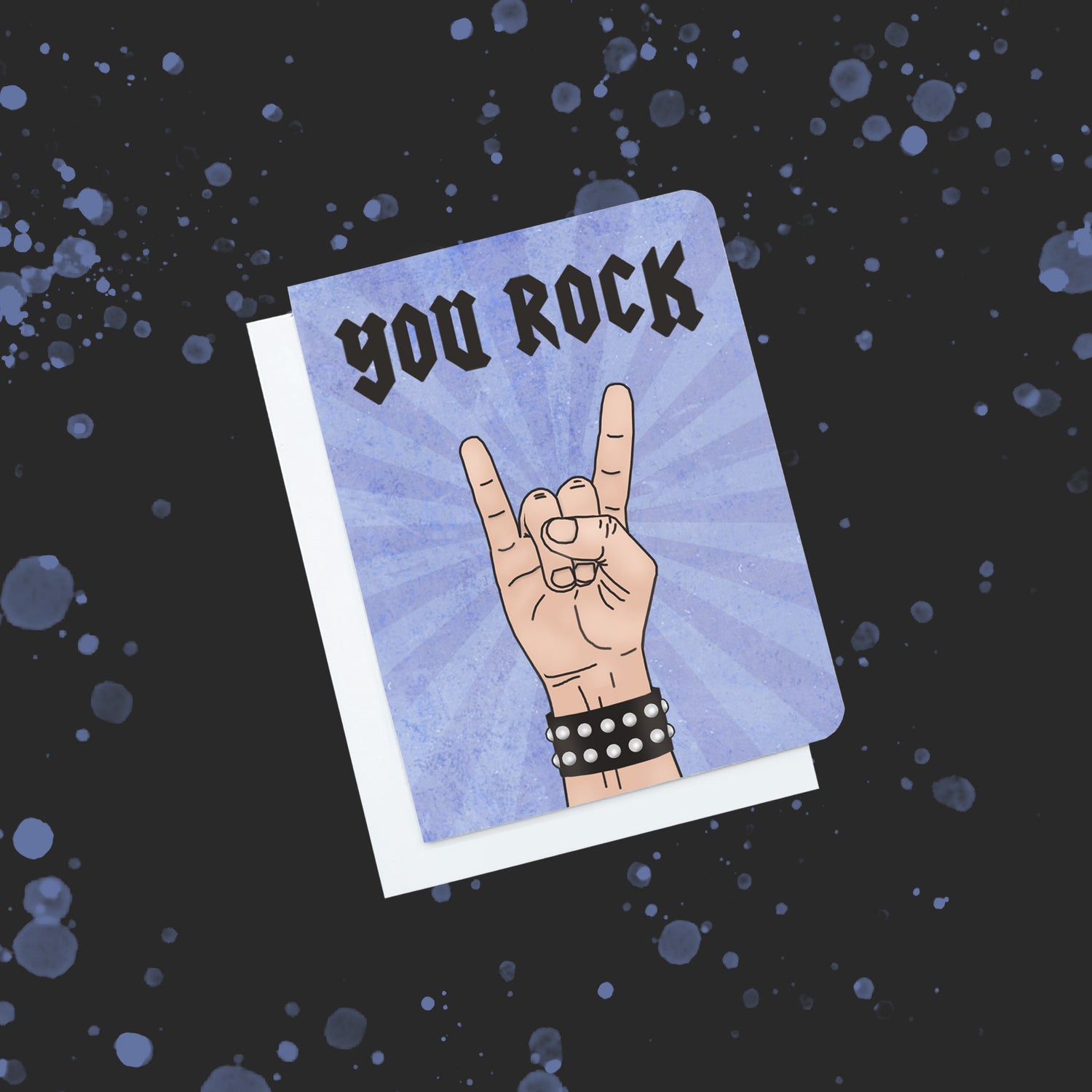 A photo of a card. It has a cartoon hand doing the rock symbol. It's wearing a studded bracelet. Text on card reads 'You Rock.'