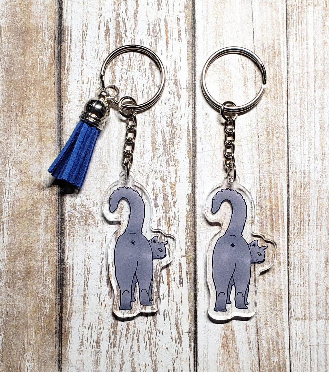 A photo of two cat key chains. The keychain has a cat butt on it.