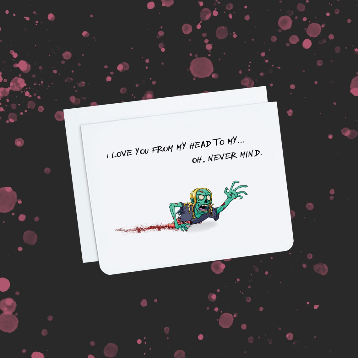A photo of a white valentine's card. It has a crawling zombie on it. It's missing half of its body. Text on card reads, 'I love you from my head to my ... oh, never mind.'