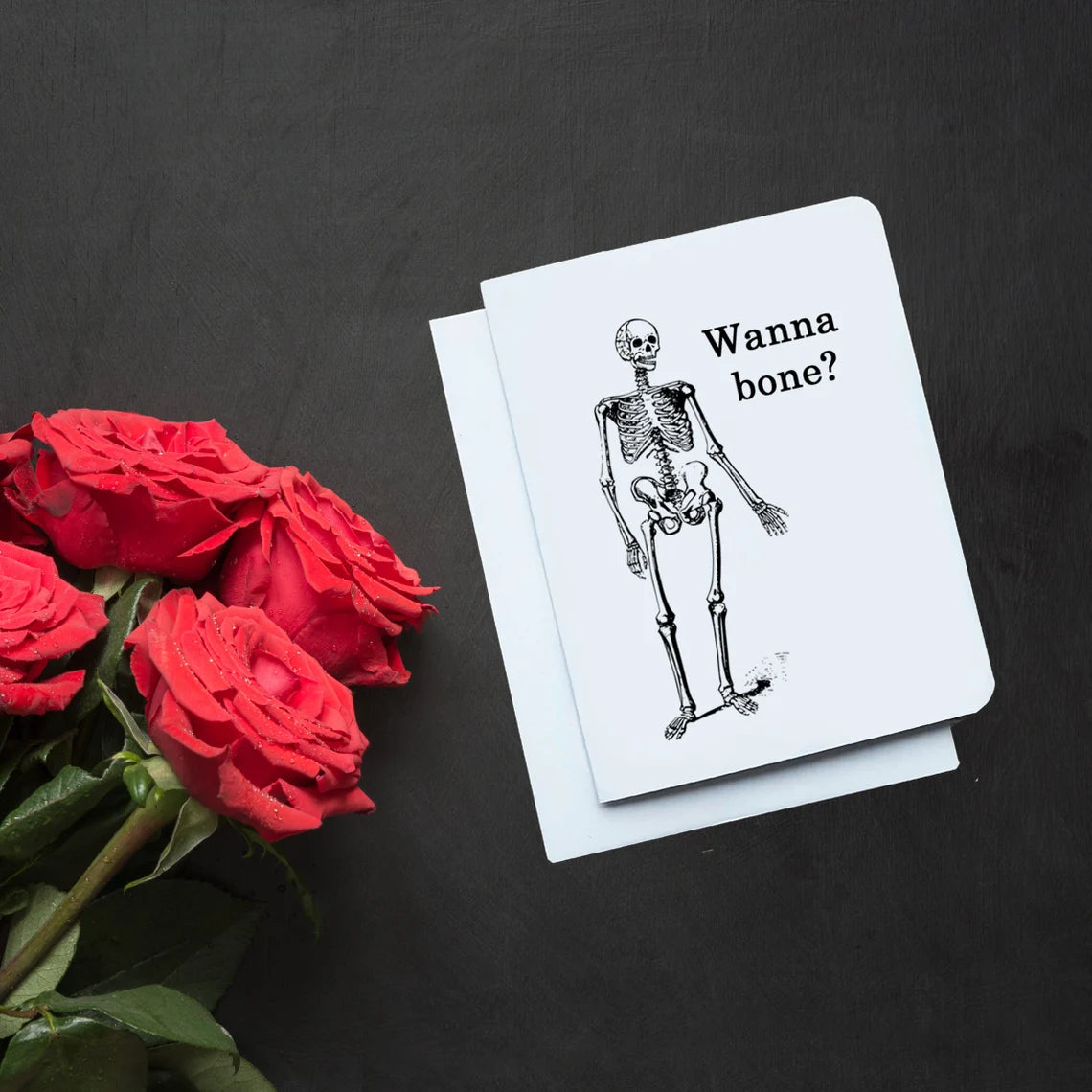 A funny Valentine's Day card. It has a cartoon skeleton on it. Text reads 'Wanna Bone?'