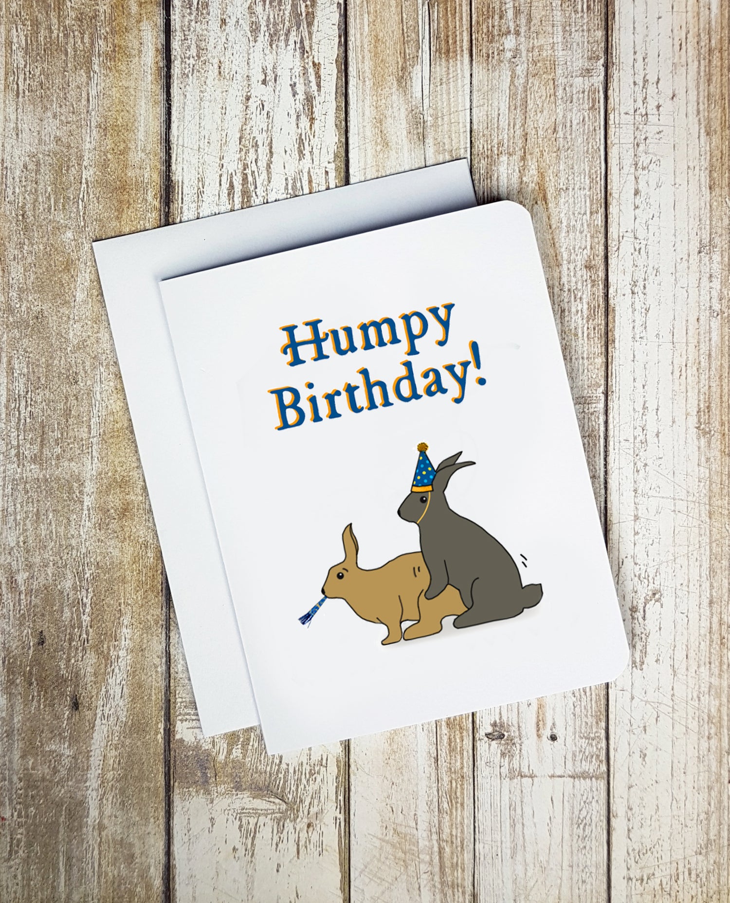 A photo of a white birthday card. It has two humping cartoon rabbits on it. Text on card reads, 'Humpy Birthday!'