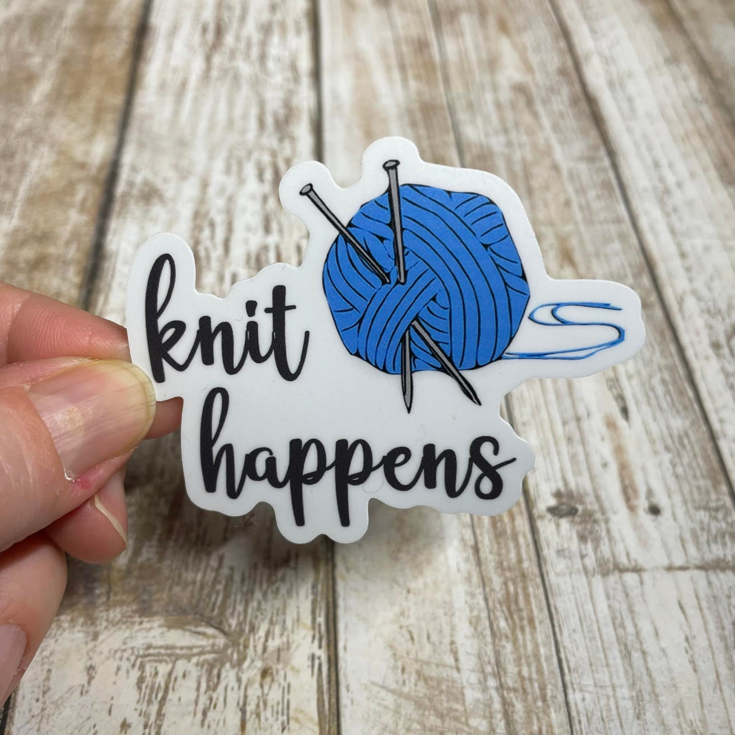 A photo of a cute sticker. It's of a cartoon ball of yarn, text on sticker reads 'Knit Happens.'
