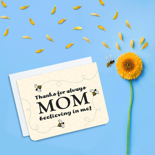 A photo of a mothers day card. It has bees buzzing around on it. Text reads, Thanks for always beelieving in me, Mom.