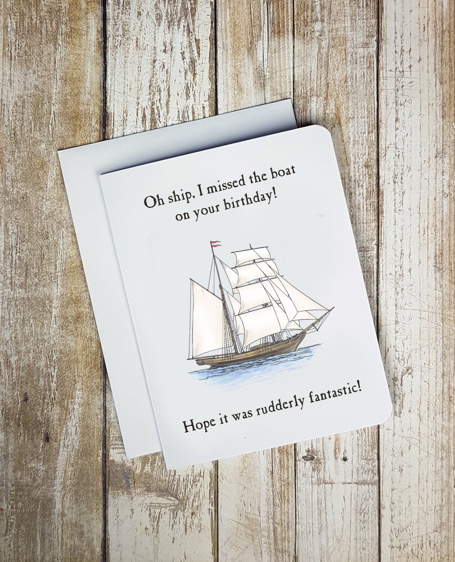 A photo of a white birthday card. It has an illustration of a tall ship on it. Text on card says, 'Oh Ship, I missed the boat on your birthday! Hope it was rudely fantastic!'