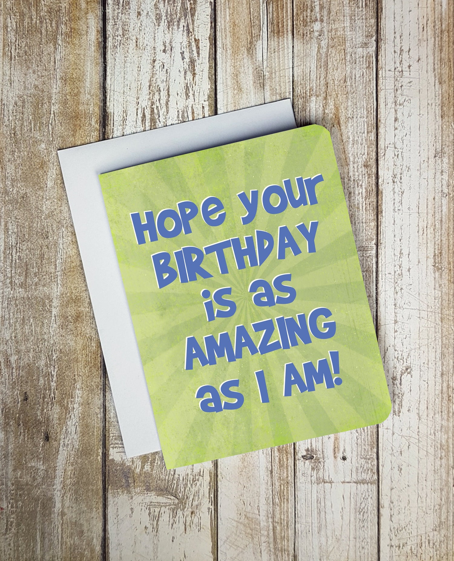A photo of a green happy birthday card. Bold blue text on card reads, 'Hope you birthday is as amazing as I am!'