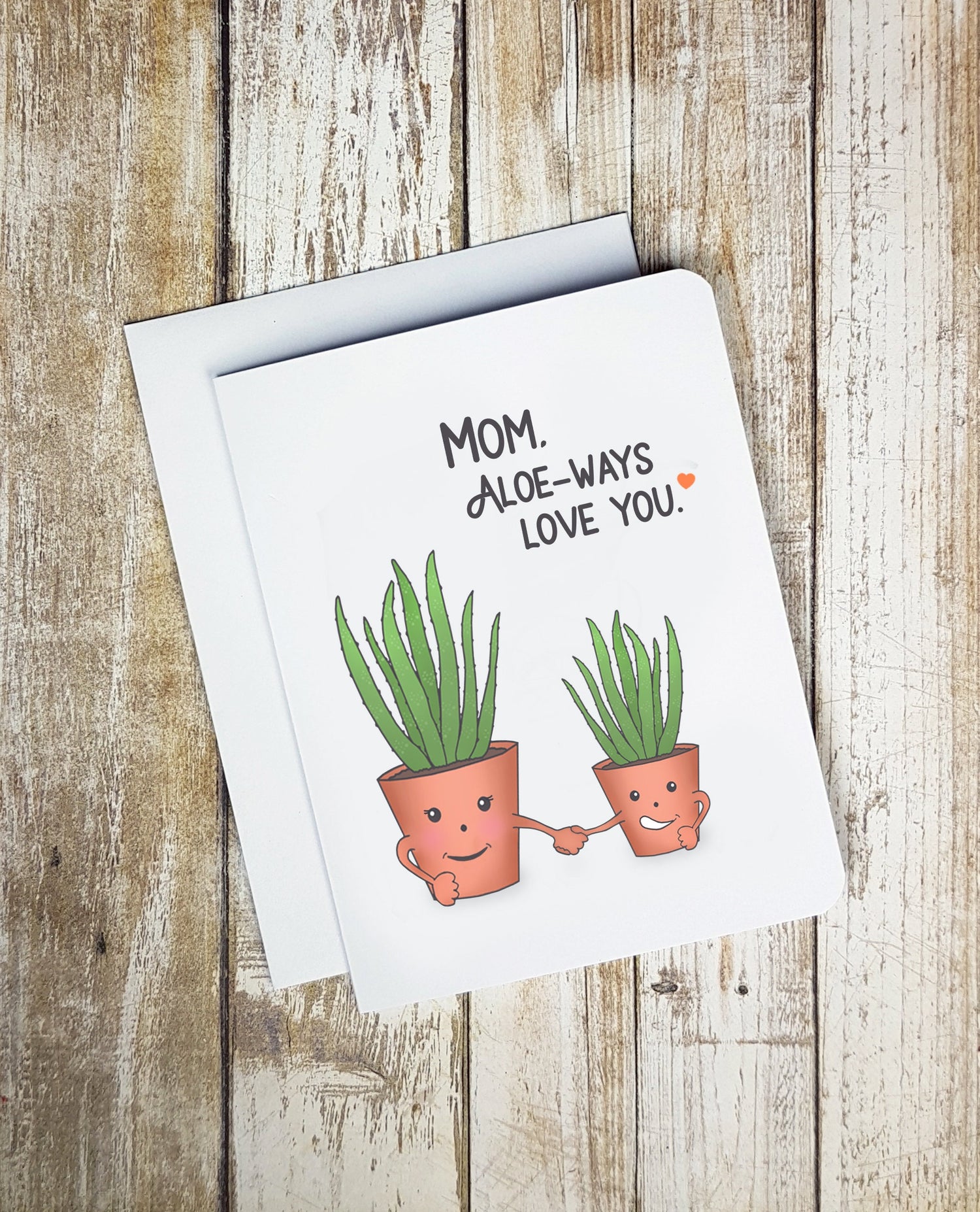 A photo of a Mother's Day card. It has 1 small 1 big potted Aloe plants. They're holding hands. Text reads, Mom. Aloe-ways love you.